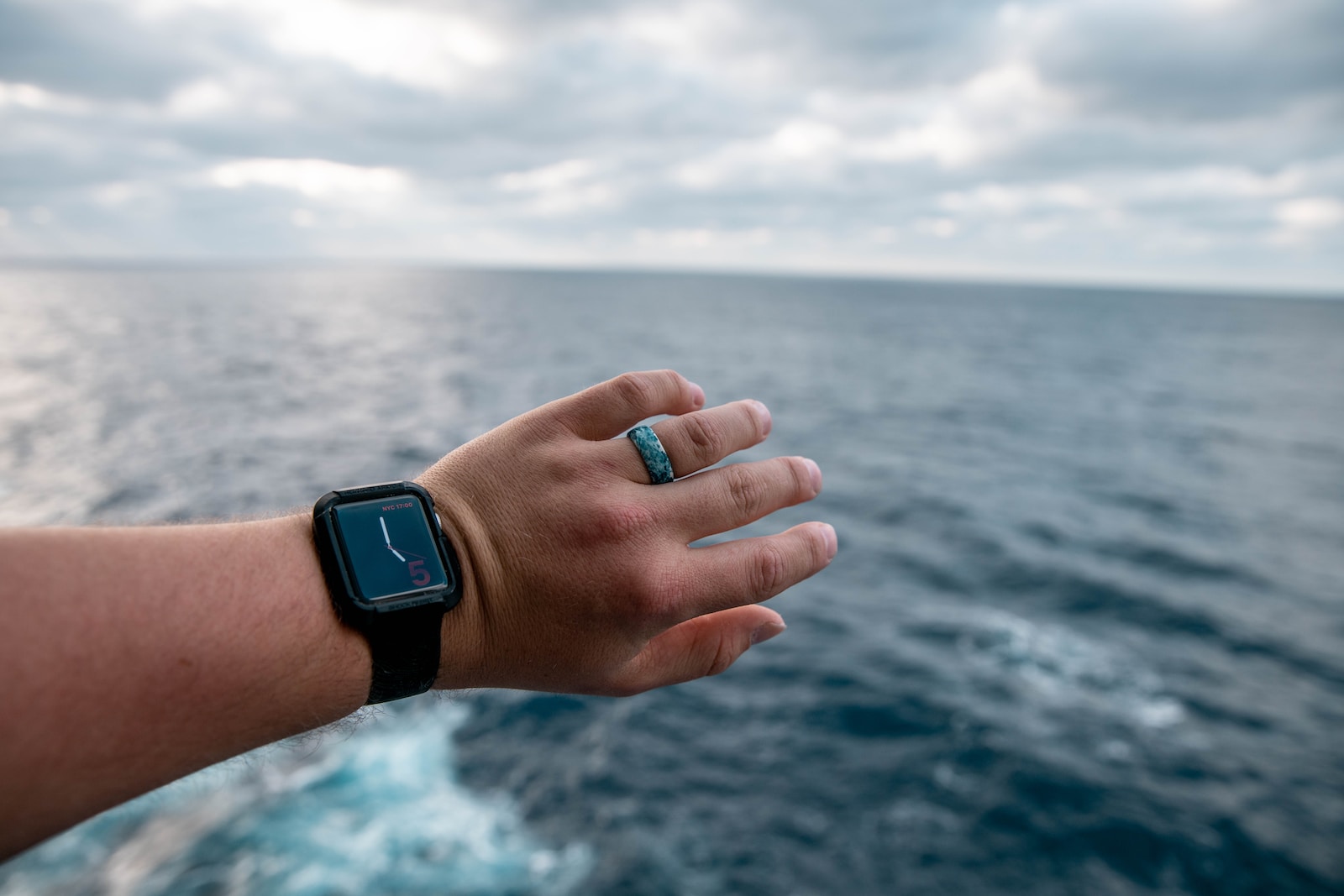 person wearing silver aluminum case apple watch with black sport band